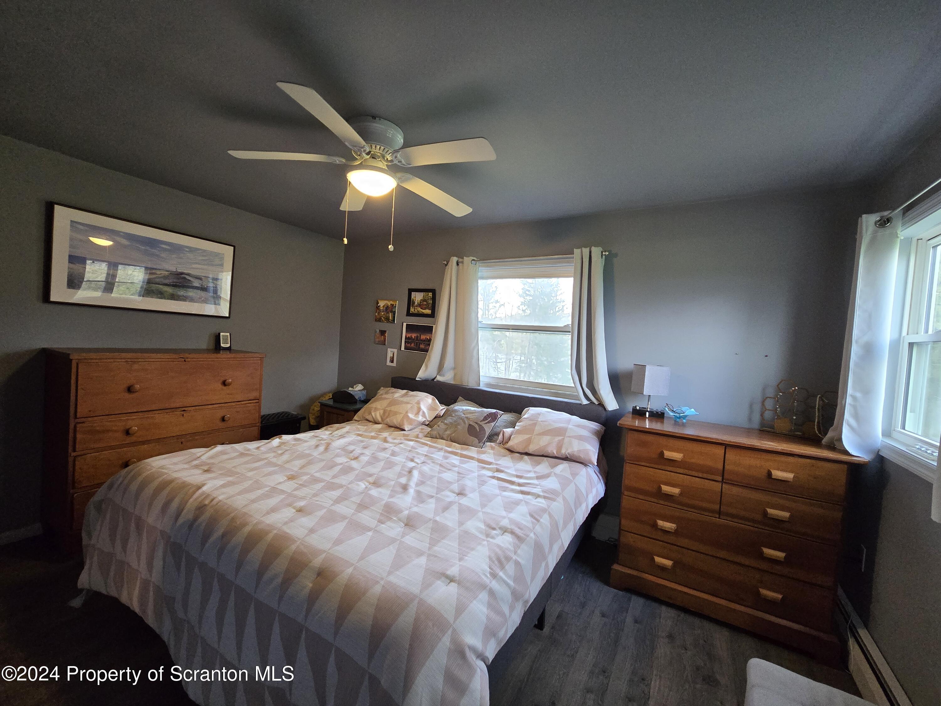 6736 Kingsley Road Kingsley, PA 18826 - Photo 25 of 42 a bedroom with a bed and a chandelier
