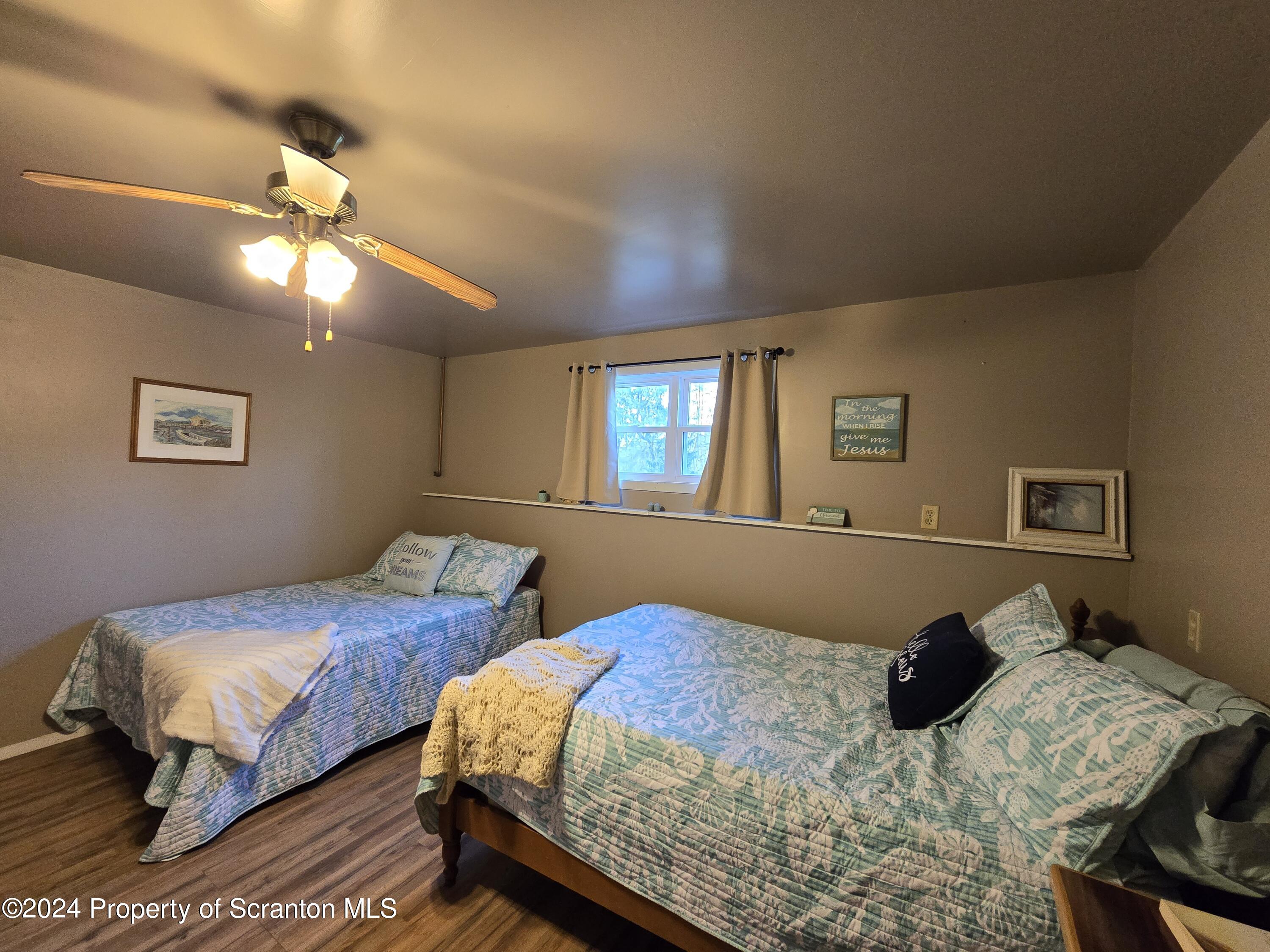 6736 Kingsley Road Kingsley, PA 18826 - Photo 31 of 42 a bedroom with two beds and a chandelier