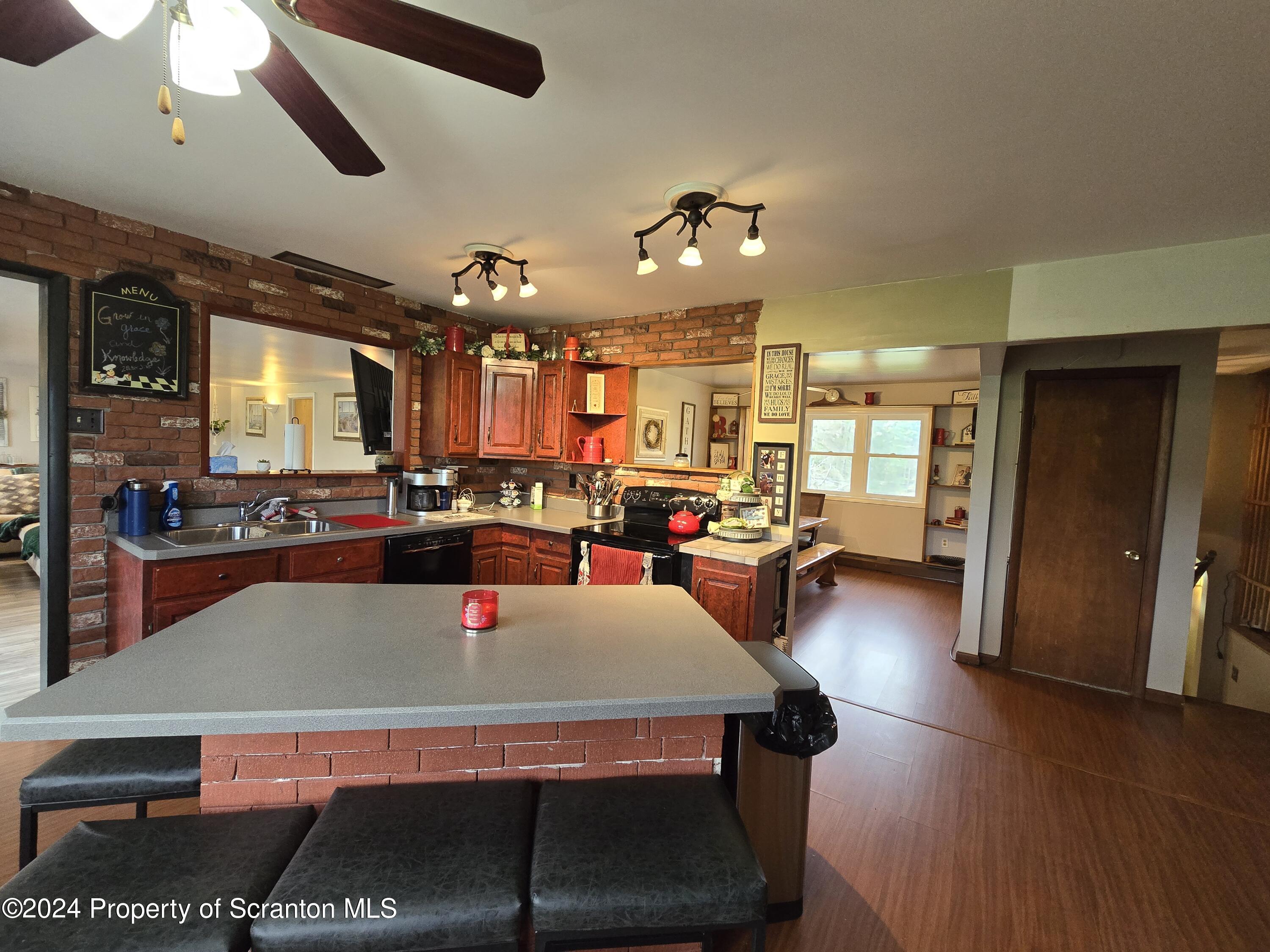 6736 Kingsley Road Kingsley, PA 18826 - Photo 9 of 42 a living room with stainless steel appliances kitchen island granite countertop a table chairs and a refrigerator