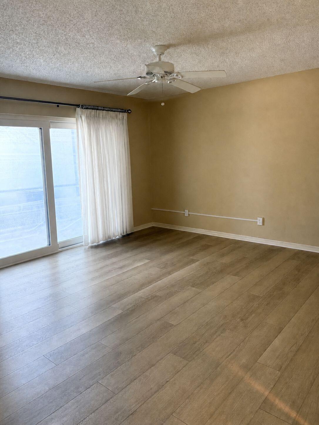 1871 Southwest Palm City Road, Unit G401 Stuart, FL 34994 - Photo 9 of 16 an empty room with wooden floor and windows