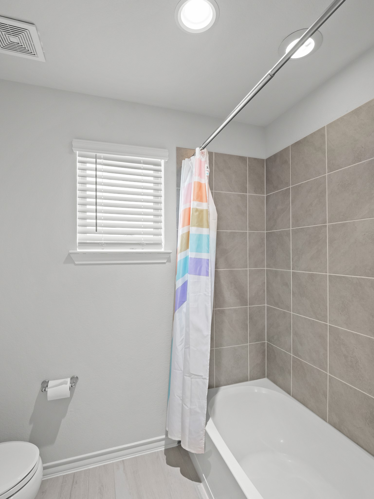353 Capstone Road Liberty Hill, TX 78642 - Photo 19 of 28 A pristine bath offers serene tiled walls and essential comforts.