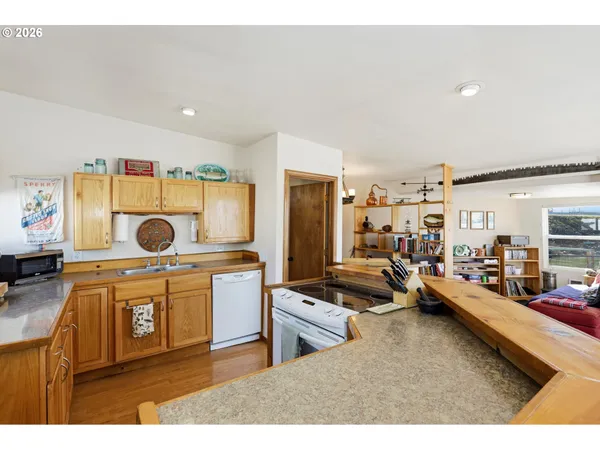 a kitchen with a stove a cabinets and a view of living room