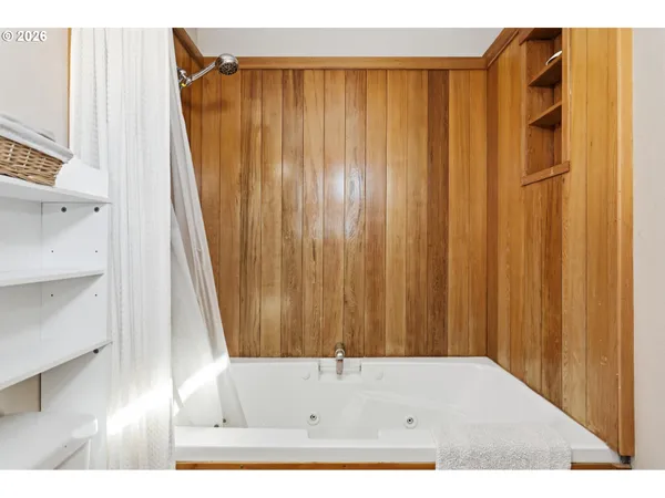 a bathroom with a shower curtain and a wooden floor