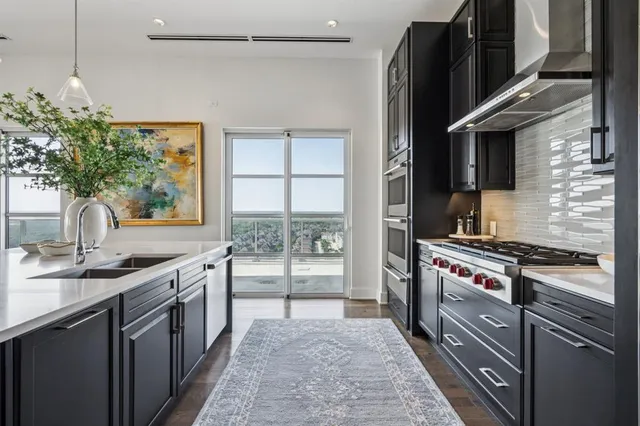 a kitchen with stainless steel appliances granite countertop a sink stove and refrigerator