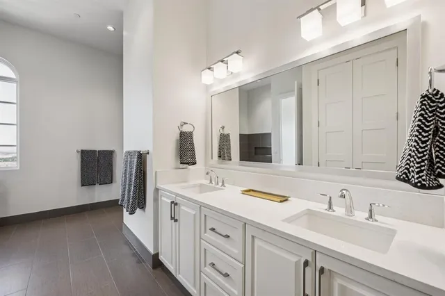 a spacious bathroom with a double vanity sink and a mirror