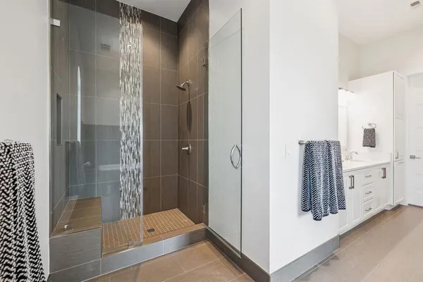 a bathroom with a bathtub and a glass door shower