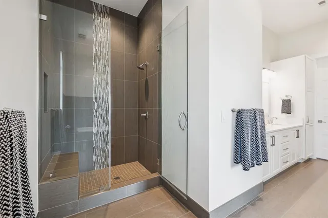 a bathroom with a bathtub and a glass door shower