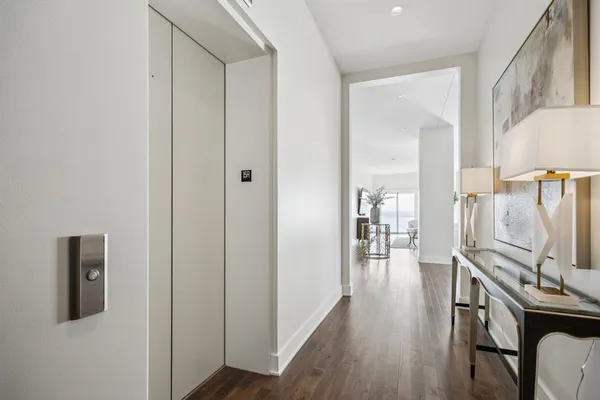 a view of a hallway with wooden floor windows a fireplace and entryway