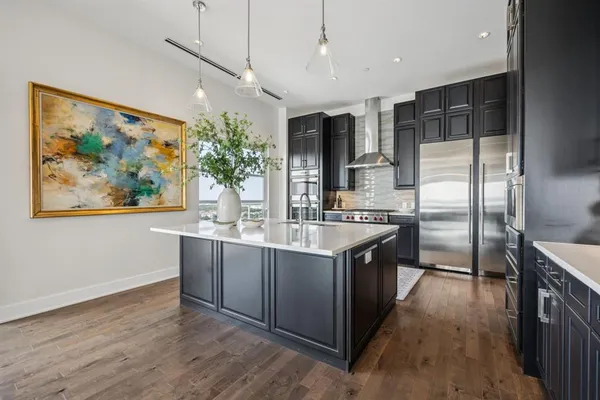 a large kitchen with stainless steel appliances granite countertop a sink and a refrigerator