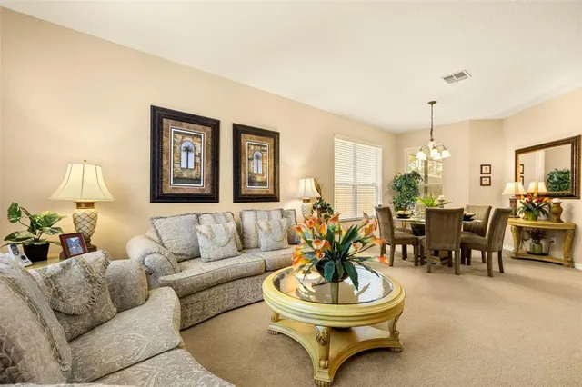 a dining room with furniture a chandelier and wooden floor
