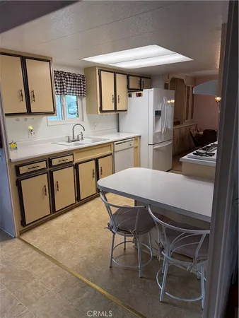 a kitchen with stainless steel appliances granite countertop a sink and white cabinets