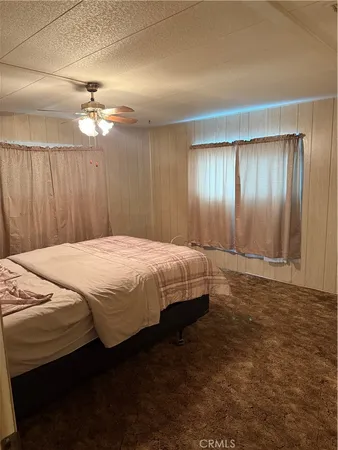 a bedroom with a bed dresser and a window