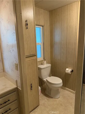 a bathroom with a granite countertop toilet and a sink