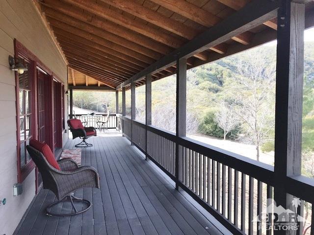 59373 Hop Patch Spring Road Mountain Center, CA 92561 - Photo 4 of 41 a view of a porch with furniture and wooden floor