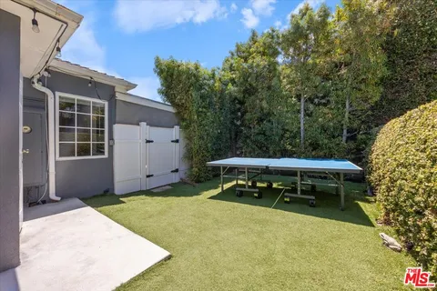 a backyard of a house with table and chairs