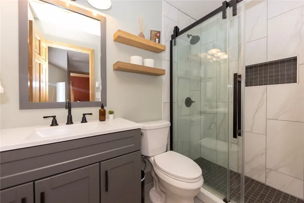 a bathroom with a sink a toilet and shower