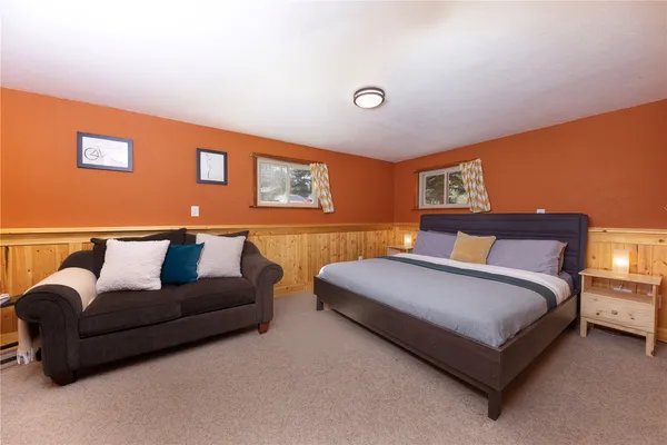 a spacious bedroom with a bed couch and a window