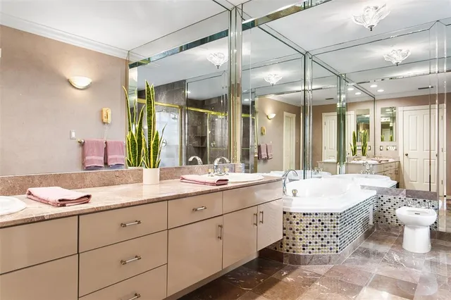 a spacious bathroom with a double vanity sink mirror and bathtub