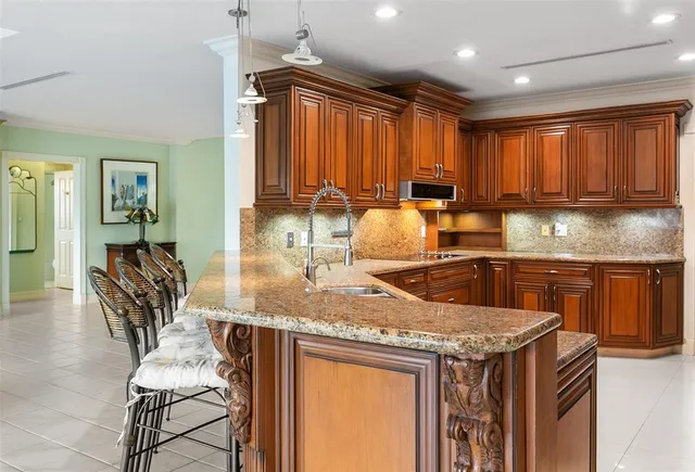 a kitchen with a stove top oven a sink a dining table and chairs