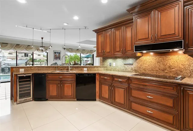 a kitchen with stainless steel appliances granite countertop a stove sink and cabinets