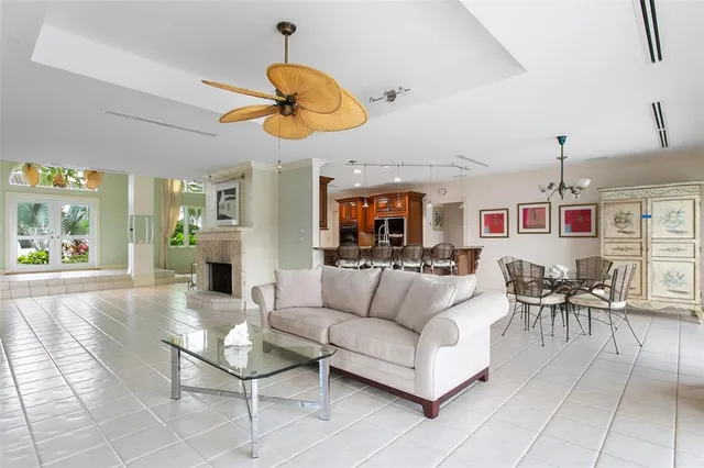 a living room with furniture kitchen view and a large window