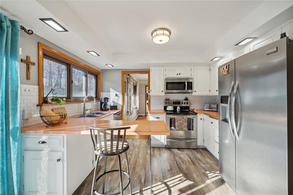 146 Jacobs Drive Boswell, PA 15531 - Photo 6 of 35 a kitchen with stainless steel appliances granite countertop a refrigerator a stove top oven and a dining table with wooden floor