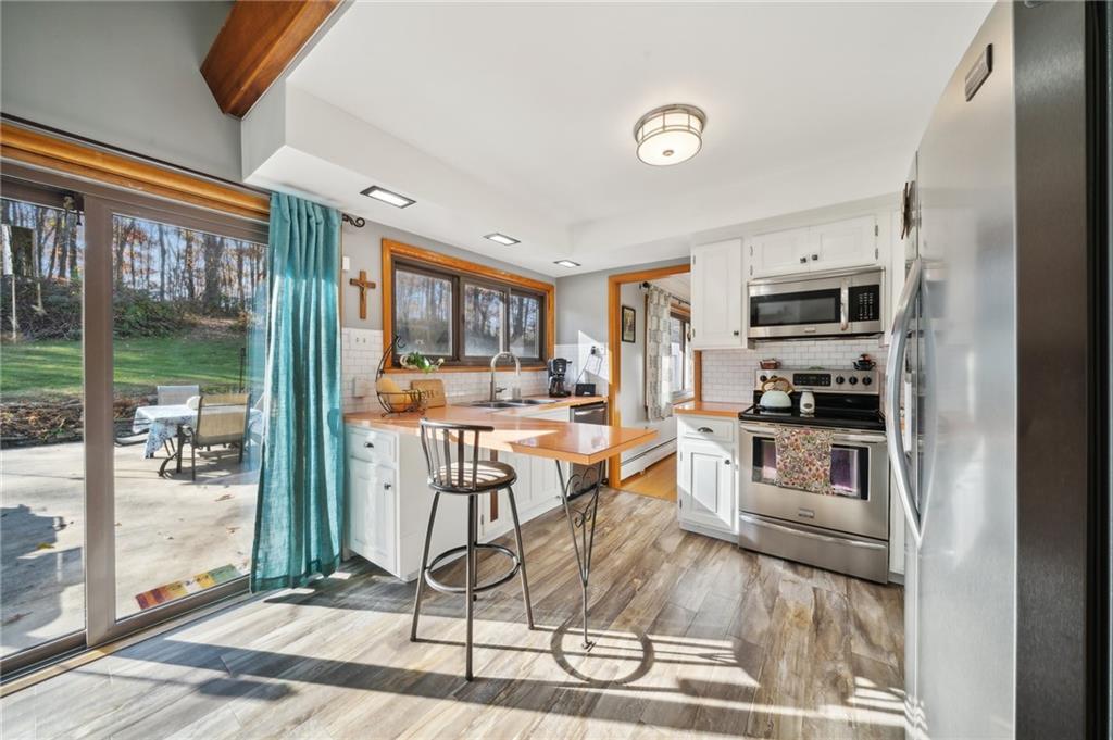 146 Jacobs Drive Boswell, PA 15531 - Photo 7 of 35 a kitchen with granite countertop a refrigerator a stove a sink and a dining table with wooden floor