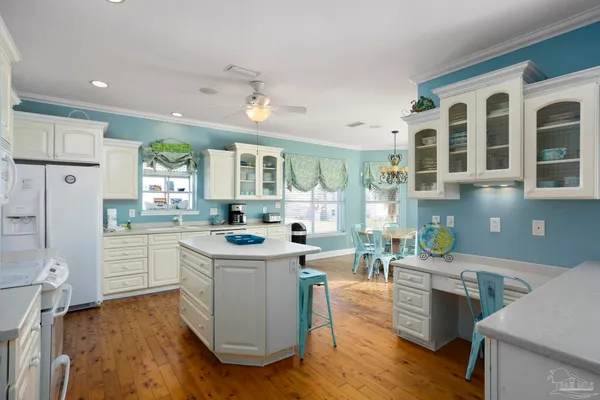 a kitchen with granite countertop a sink and a white wooden cabinets