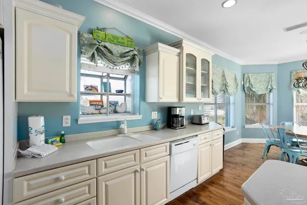 a kitchen with stainless steel appliances kitchen island granite countertop a table chairs sink and cabinets