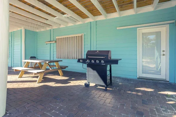 a kitchen with stainless steel appliances granite countertop a stove top oven a sink dishwasher a dining table and chairs with wooden floor