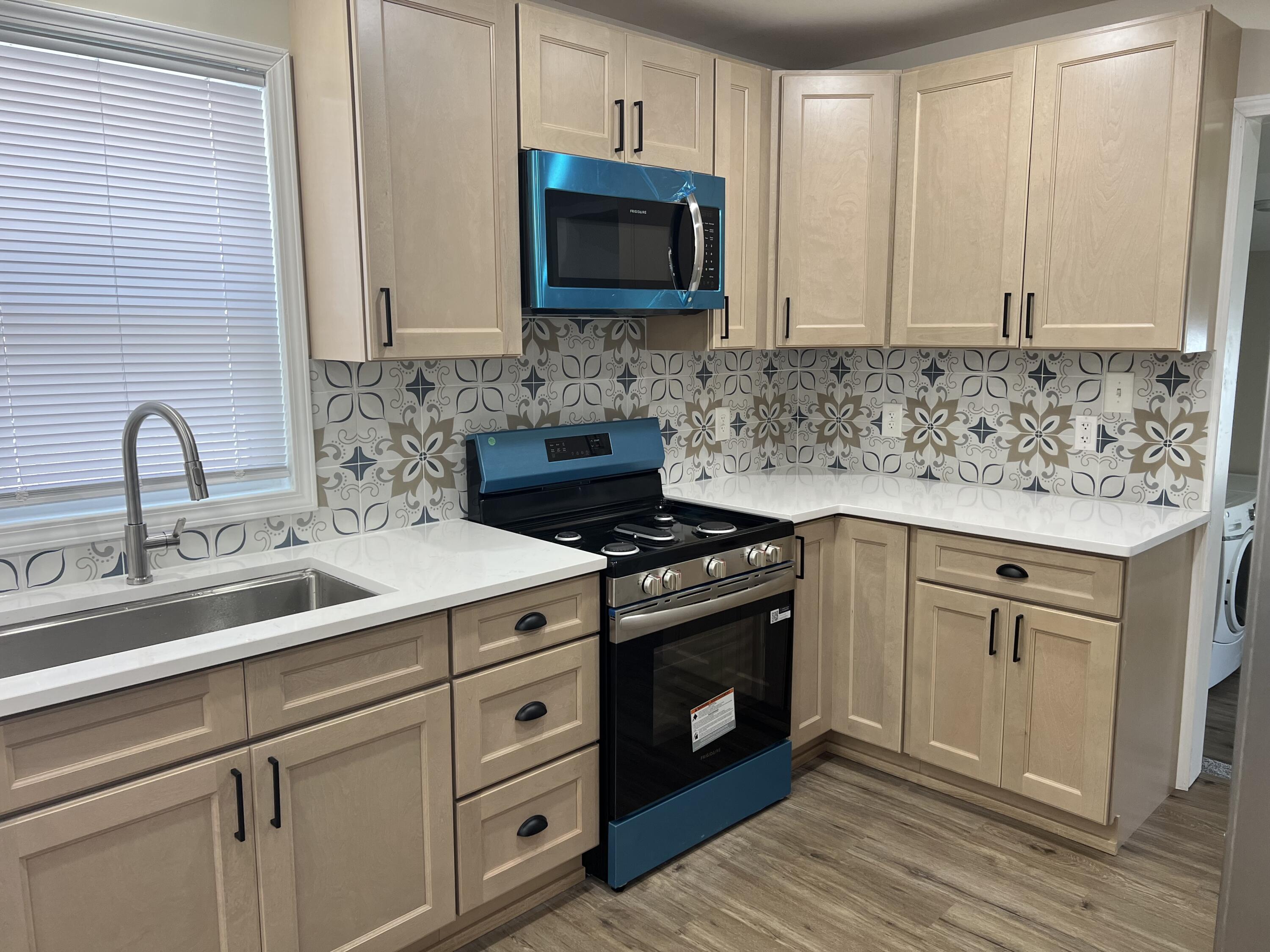 3851 Maple Street Hobart, IN 46342 - Photo 15 of 28 a kitchen with stainless steel appliances granite countertop a sink stove and cabinets