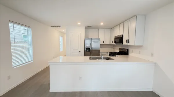 a kitchen with kitchen island white cabinets and refrigerator