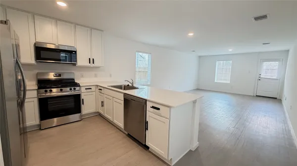 a kitchen with stainless steel appliances a stove microwave and sink