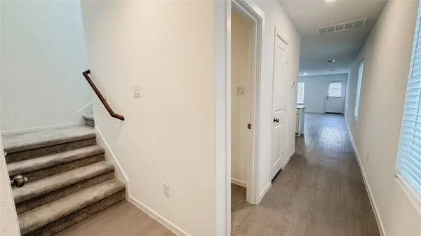 a view of a hallway with wooden floor and entryway