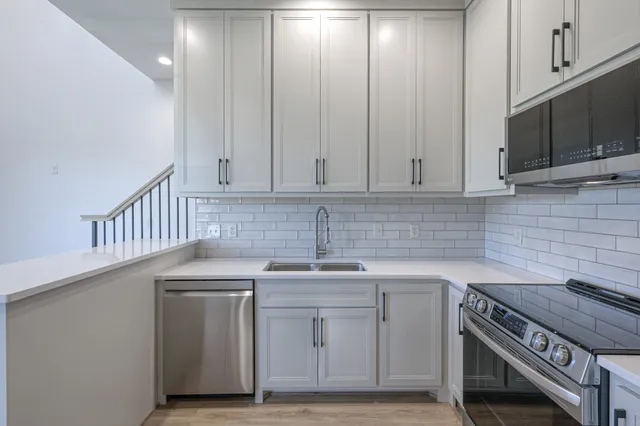 a kitchen with stainless steel appliances white cabinets and a sink