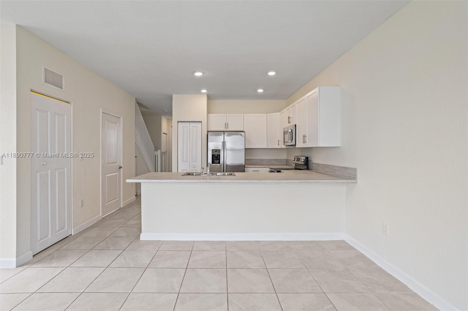 3411 West 112th Terrace Hialeah, FL 33018 - Photo 11 of 42 a view of kitchen with stainless steel appliances granite countertop white cabinets and refrigerator