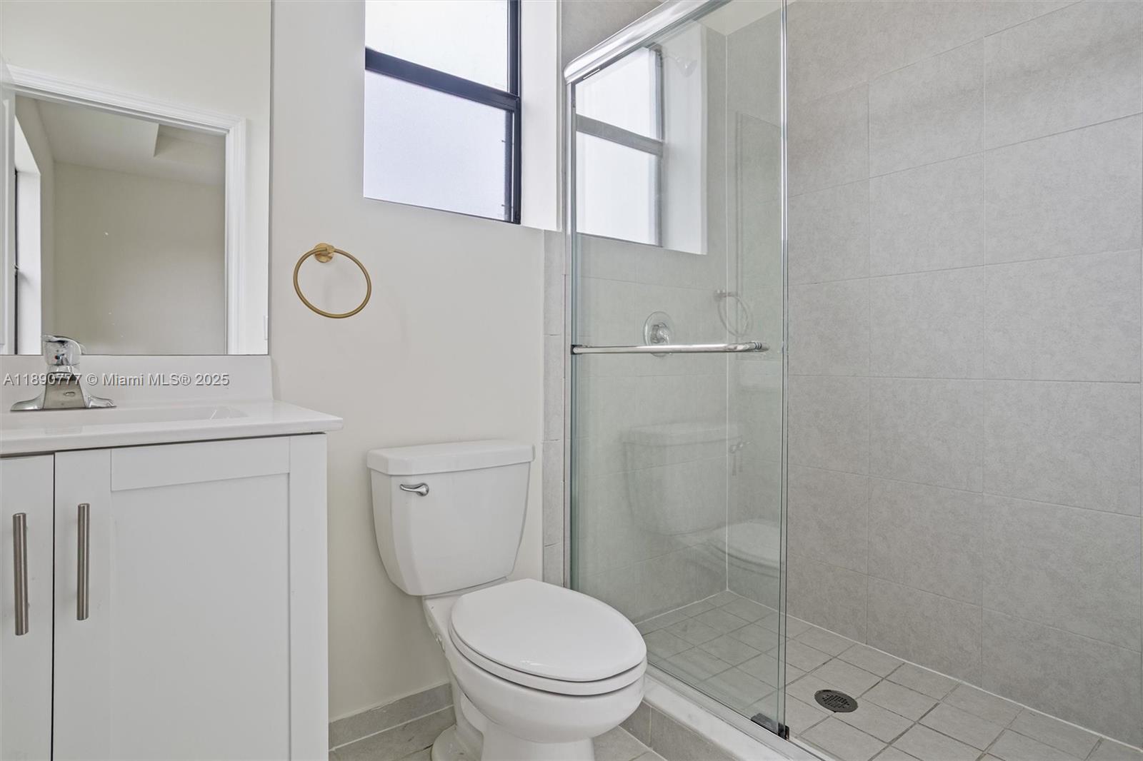 3411 West 112th Terrace Hialeah, FL 33018 - Photo 20 of 42 a bathroom with a toilet sink vanity and mirror