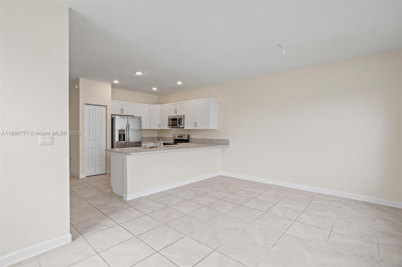 3411 West 112th Terrace Hialeah, FL 33018 - Photo 10 of 42 a kitchen with white cabinets and refrigerator