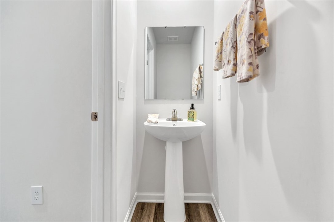 150 Queens Mill Court Pendleton, SC 29670 - Photo 12 of 37 This bathroom features a contemporary pedestal sink and a sleek mirror, complemented by rich flooring.