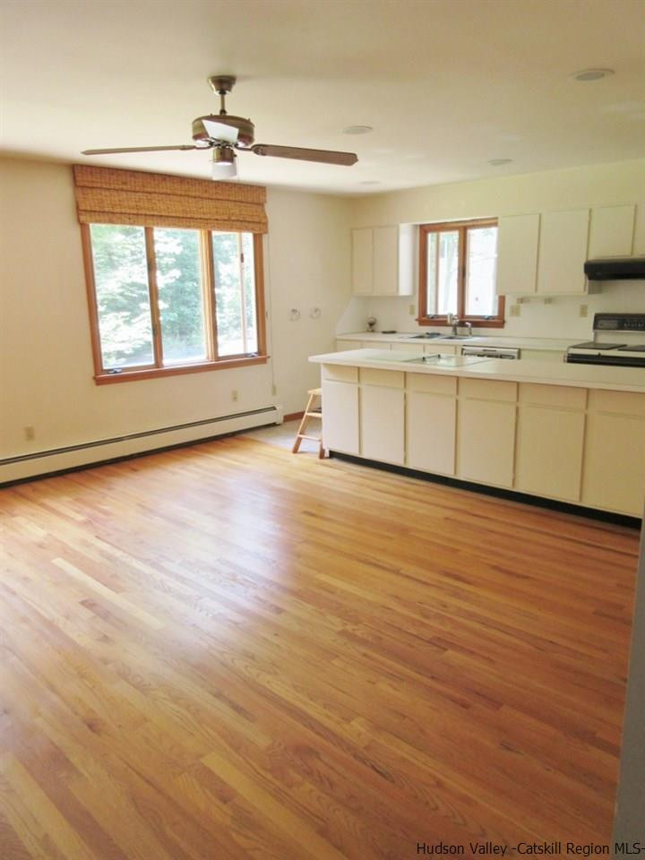 48 Saxton Flats Road Saugerties, NY 12477 - Photo 6 of 21 a large white kitchen with granite countertop a stove a sink and white cabinets with wooden floor