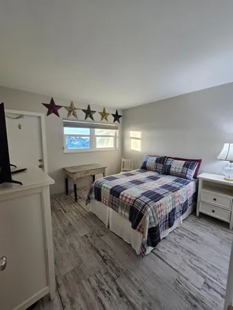 a bedroom with a bed and wooden floor