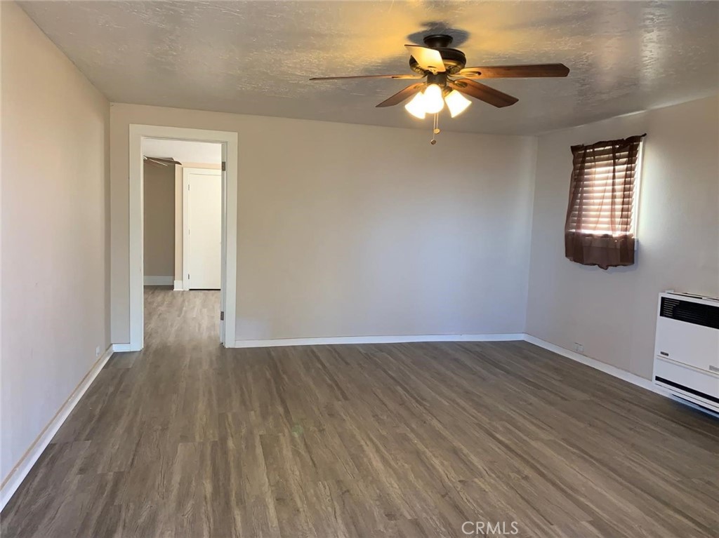 9548 White Road Phelan, CA 92371 - Photo 3 of 8 a view of an empty room with window and wooden floor