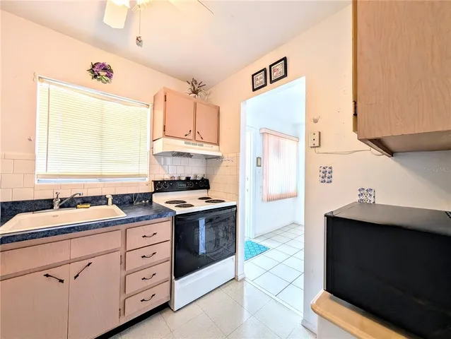 a kitchen with a sink stove and refrigerator