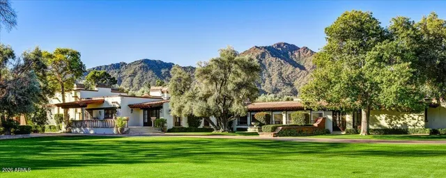 a view of a big house with a big yard and large trees