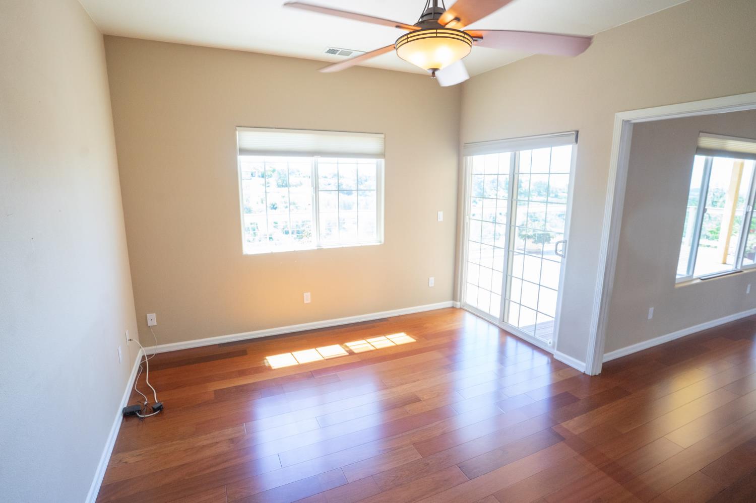 3235 Hagen Road Valley Springs, CA 95252 - Photo 18 of 56 an empty room with wooden floor fan and windows
