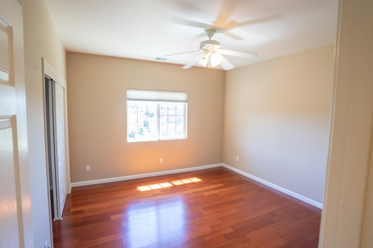 3235 Hagen Road Valley Springs, CA 95252 - Photo 24 of 56 an empty room with wooden floor chandelier fan and windows