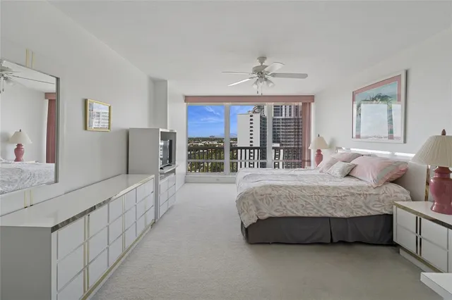 a spacious bedroom with a bed couch and a large window