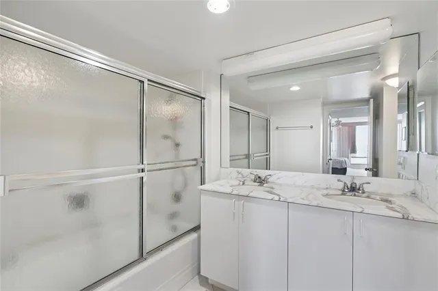 a bathroom with a double vanity sink mirror and shower
