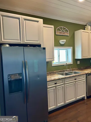 a kitchen with stainless steel appliances granite countertop a refrigerator and a sink