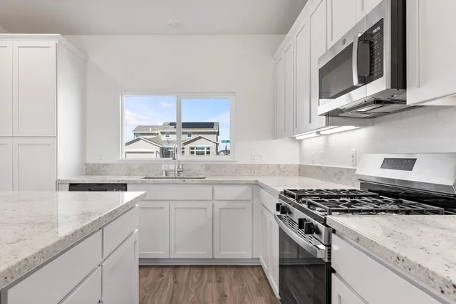 a kitchen with stainless steel appliances granite countertop a sink stove and microwave